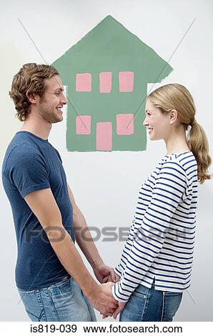 Couple with house painted on the wall View Large Photo Image Stock Photo - Couple with house painted on the wall. Fotosearch