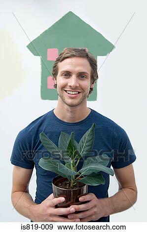 Man holding a house plant View Large Photo Image Stock Photo - Man holding a house plant. Fotosearch