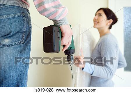 Man with electric drill and woman with picture View Large Photo Image Stock Photo - Man with electric drill and woman with picture. Fotosearch