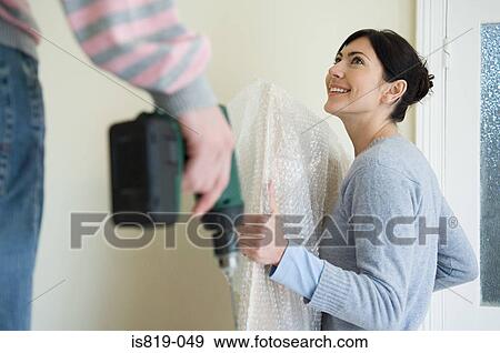 Man with electric drill and woman with picture View Large Photo Image Stock Photo - Man with electric drill and woman with picture. Fotosearch