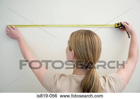 Woman measuring a wall View Large Photo Image Stock Photograph - Woman measuring a wall. Fotosearch