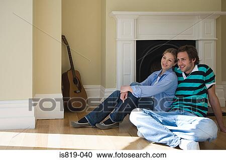 Stock Image - Young couple sitting on floor. Fotosearch