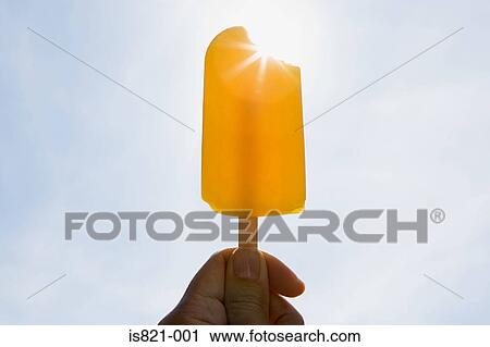 Person holding an ice lolly on a sunny day View Large Photo Image Stock Image - Person holding an ice lolly on a sunny day. Fotosearch