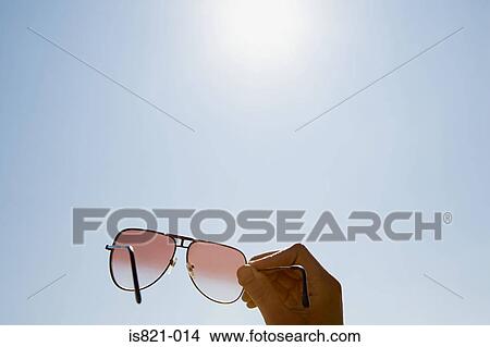 Person holding sunglasses View Large Photo Image Picture - Person holding sunglasses. Fotosearch