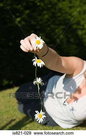 Woman holding a daisy chain View Large Photo Image Stock Photo - Woman holding a daisy chain. Fotosearch