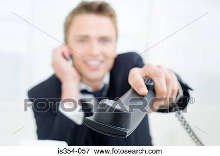 Businessman handing telephone handset View Large Photo Image Stock Photo - Businessman handing telephone handset. Fotosearch