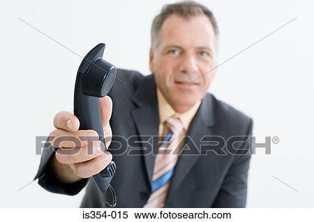 Stock Photography - Businessman holding telephone handset. Fotosearch