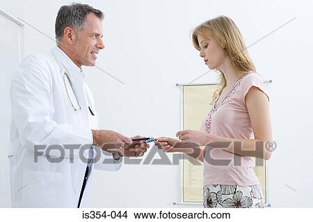 Doctor giving tablets to patient View Large Photo Image Picture - Doctor giving tablets to patient. Fotosearch