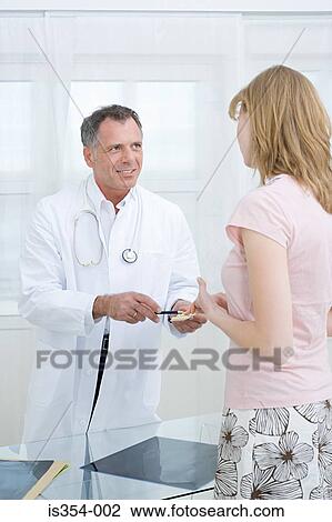 Doctor giving tablets to patient View Large Photo Image Stock Image - Doctor giving tablets to patient. Fotosearch