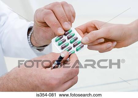 Stock Image - Doctor handing over tablets. Fotosearch