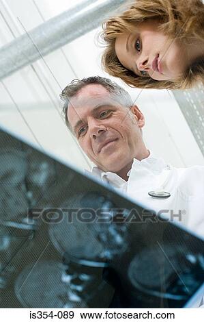 Stock Photo - Doctors looking at MRI scans. Fotosearch