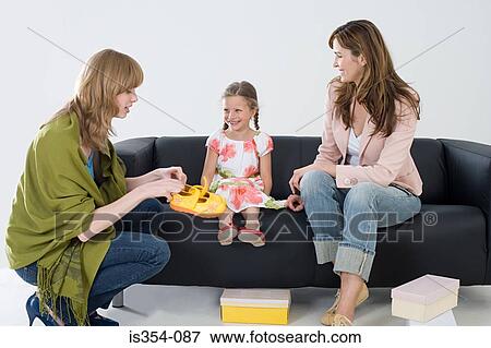 Girl and mother with shoe shop assistant View Large Photo Image Stock Photo - Girl and mother with shoe shop assistant. Fotosearch