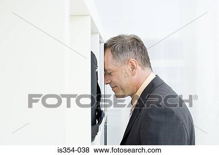 Stock Photo - Man leaning on shelving. Fotosearch