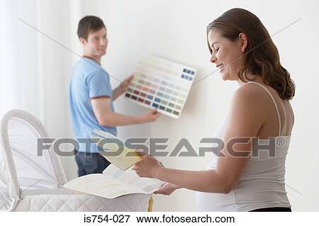 Couple choosing colours for nursery View Large Photo Image Stock Photo - Couple choosing colours for nursery. Fotosearch
