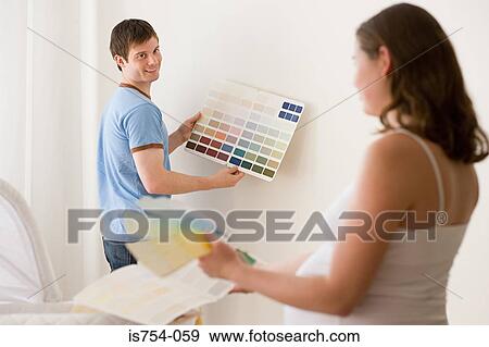 Couple choosing colours for nursery View Large Photo Image Stock Photo - Couple choosing colours for nursery. Fotosearch