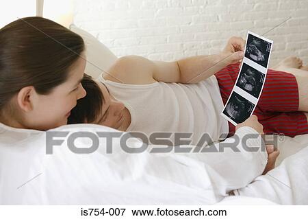 Couple looking at baby scans View Large Photo Image Stock Photo - Couple looking at baby scans. Fotosearch