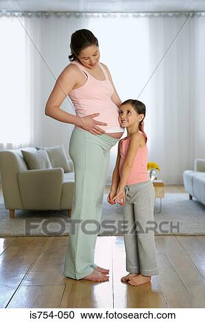 Daughter listening to mothers stomach View Large Photo Image Stock Image - Daughter listening to mothers stomach. Fotosearch