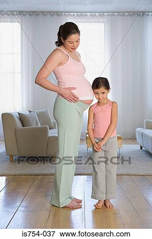 Daughter listening to mothers stomach View Large Photo Image Stock Photo - Daughter listening to mothers stomach. Fotosearch
