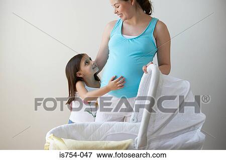 Daughter touching mothers stomach View Large Photo Image Stock Photo - Daughter touching mothers stomach. Fotosearch