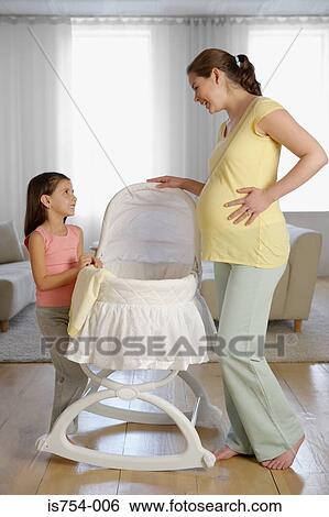 Mother and daughter looking at a crib View Large Photo Image Stock Photograph - Mother and daughter looking at a crib. Fotosearch