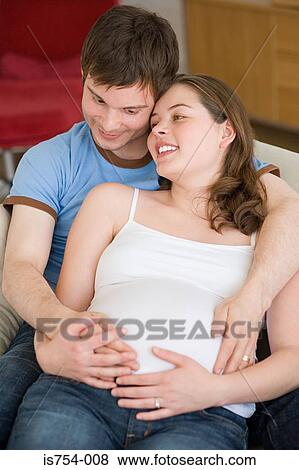 Stock Photo - Pregnant woman and partner hugging. Fotosearch