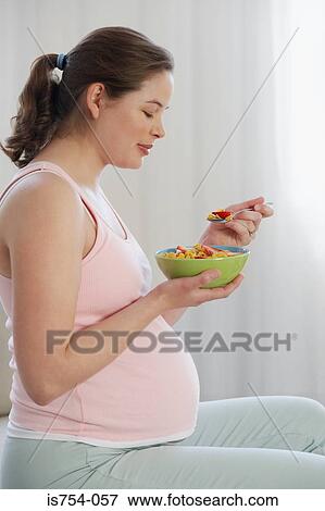 Stock Photo - Pregnant woman holding bowl of cereal. Fotosearch