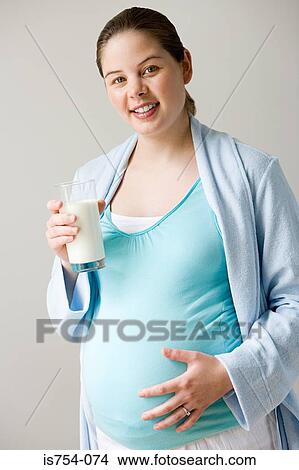 Pregnant woman holding glass of milk View Large Photo Image Picture - Pregnant woman holding glass of milk. Fotosearch
