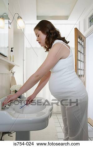 Pregnant woman holding toothbrush View Large Photo Image Picture - Pregnant woman holding toothbrush. Fotosearch