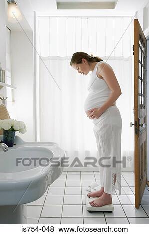 Pregnant woman on weight scales View Large Photo Image Stock Photo - Pregnant woman on weight scales. Fotosearch