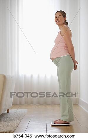 Pregnant woman on weight scales View Large Photo Image Stock Photography - Pregnant woman on weight scales. Fotosearch