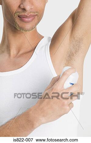 Man applying deodorant View Large Photo Image Stock Photo - Man applying deodorant. Fotosearch