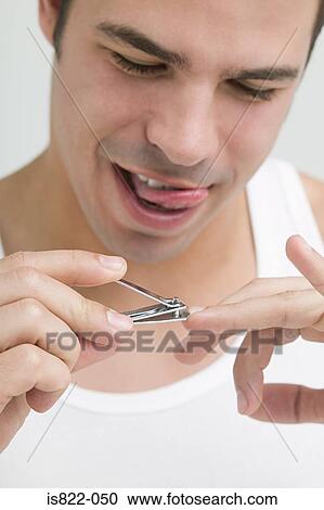 Stock Image - Man clipping his finger nails. Fotosearch