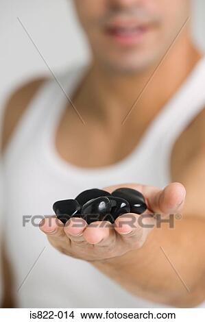 Picture - Man holding stones. Fotosearch