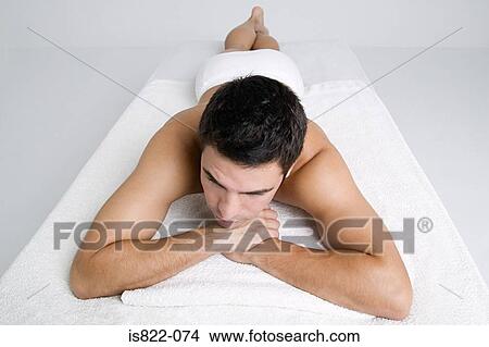 Picture - Man lying on massage table. Fotosearch