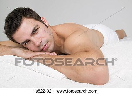 Stock Image - Man lying on massage table. Fotosearch