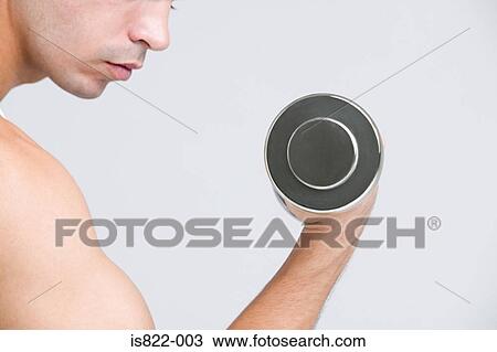 Stock Image - Man using dumbbell. Fotosearch
