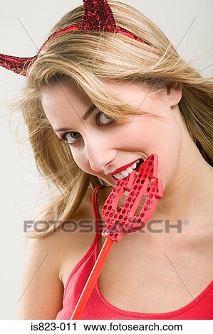Stock Image - Beautiful woman wearing a devil costume. Fotosearch