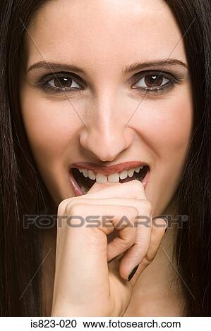 Woman biting her finger View Large Photo Image Stock Image - Woman biting her finger. Fotosearch