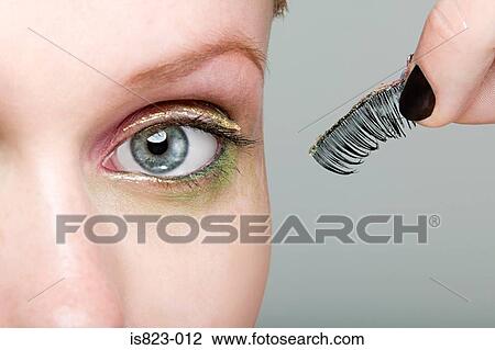 Stock Image - Woman holding a false eyelash. Fotosearch
