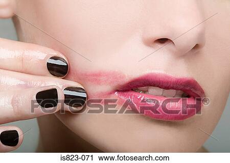 Woman smearing lipstick on face View Large Photo Image Stock Image - Woman smearing lipstick on face. Fotosearch