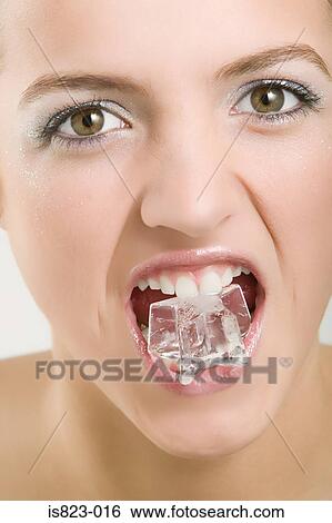 Stock Photograph - Woman with an ice cube in her mouth. Fotosearch