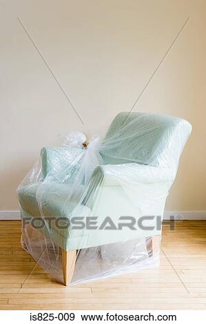 Stock Photo - Arm chair protected by plastic. Fotosearch