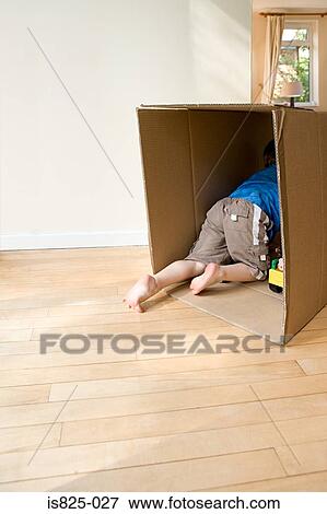 Boy in a cardboard box View Large Photo Image Stock Photo - Boy in a cardboard box. Fotosearch
