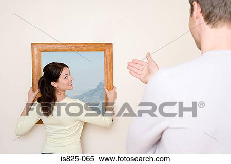 Stock Photography - Couple hanging picture. Fotosearch