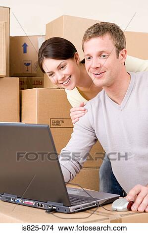 Picture - Couple looking at laptop. Fotosearch
