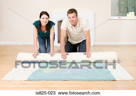Couple rolling out a rug View Large Photo Image Stock Image - Couple rolling out a rug. Fotosearch
