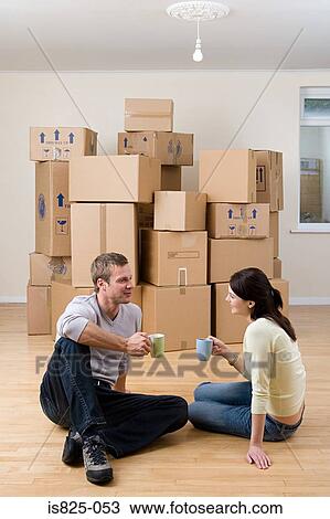 Stock Image - Couple taking a break from unpacking. Fotosearch