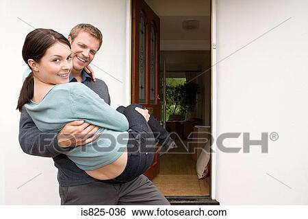 Man carrying his wife into new house View Large Photo Image Stock Photograph - Man carrying his wife into new house. Fotosearch