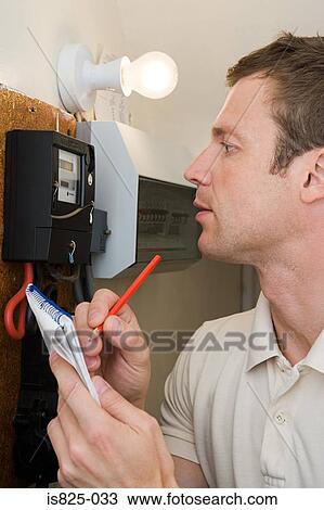 Stock Image - Man looking at meter. Fotosearch