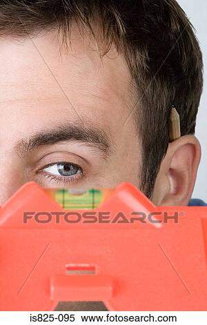 Man looking at spirit level View Large Photo Image Stock Photography - Man looking at spirit level. Fotosearch